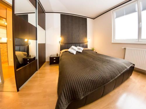 a bedroom with a large bed and a large mirror at Arpad Bridge Apartments in Budapest