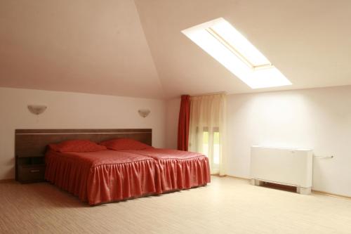 a bedroom with a bed with a red bedspread at Hotel Alafrangite in Plovdiv