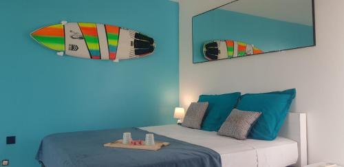- une chambre avec un lit et une planche de surf sur le mur dans l'établissement Vue Mer & Accès Direct à la Plage avec Magnifique Piscine, à Saint-François