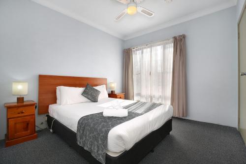 a hotel room with a large bed and a window at New England Motor Inn in Armidale
