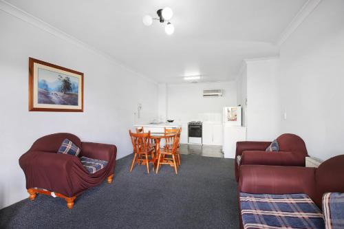 a living room with two couches and a table at New England Motor Inn in Armidale