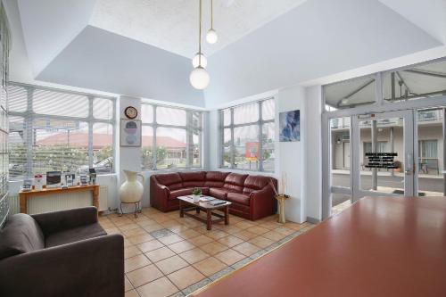 a living room with a couch and a table at New England Motor Inn in Armidale