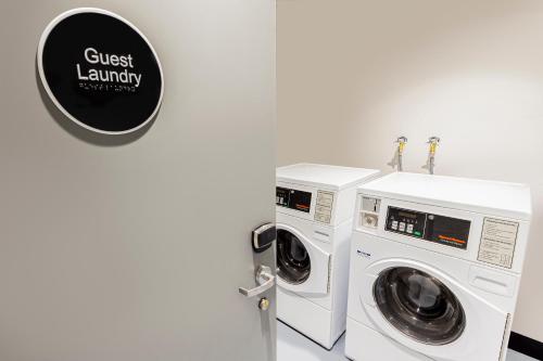two washing machines and a sign that reads guest laundry at Brady Hotels Jones Lane in Melbourne