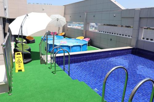 an indoor swimming pool with green flooring and an inflatable at Western Bay Marina Hotel in Pyeongtaek