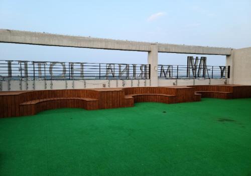 a balcony with benches on a building with green grass at Western Bay Marina Hotel in Pyeongtaek