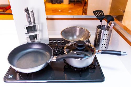 a kitchen stove with two pots and pans on it at Good Day Hotel in Chatan