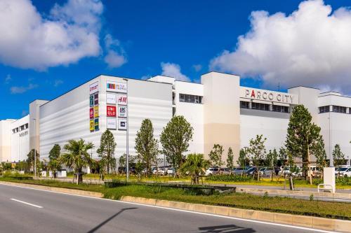 a white building on the side of a road at Good Day Hotel in Chatan