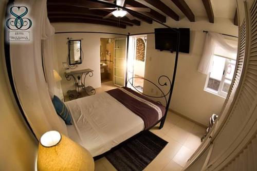 a small bedroom with a bed and a television at Hotel Tres Sofias in Querétaro