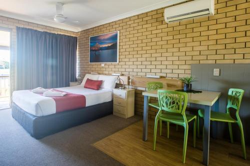 a hotel room with a bed and a table and chairs at Iluka Motel in Iluka