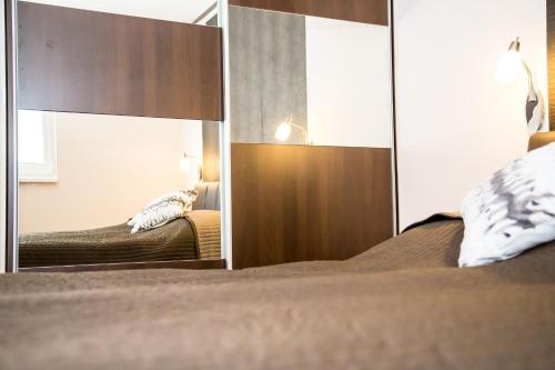 a bedroom with two beds and a mirror at Arpad Bridge Apartments in Budapest