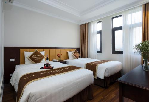 a hotel room with two beds and a window at An Phu Ha Long Villa in Ha Long