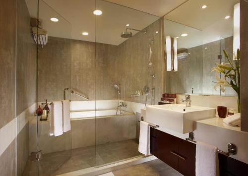 a bathroom with a sink and a tub and a shower at Oakwood Residence Shanghai in Shanghai