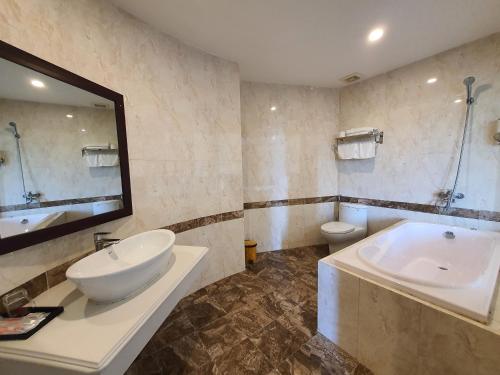 bagno con lavandino, vasca e servizi igienici di Khách Sạn Hoàng Gia II a Thái Bình