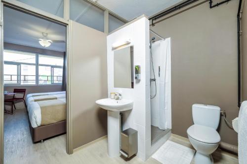 a bathroom with a toilet sink and a shower at Gondwana City Art in Noumea