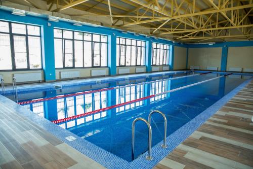 a large swimming pool with blue walls and windows at Гостиничный комплекс Be Fine in Besqaynar