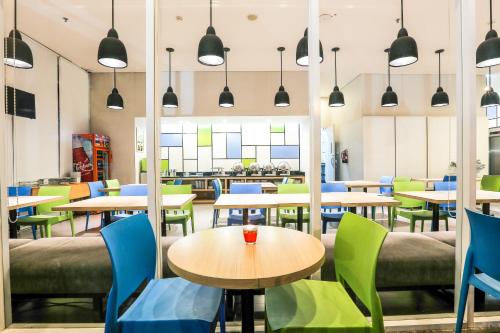 a restaurant with tables and chairs and lights at Hotel Citradream Bandung in Bandung