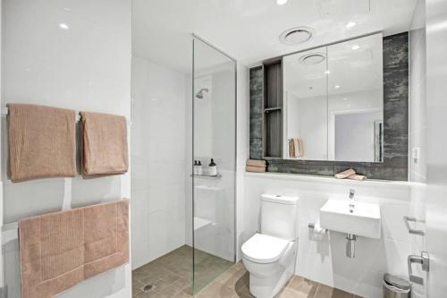 a bathroom with a toilet and a sink and a shower at Modern Studio Apartment in Chatswood in Sydney