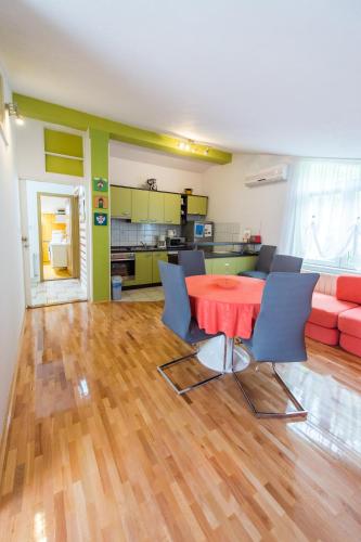 a living room with a red table and blue chairs at Apartmani Galić in Ploče