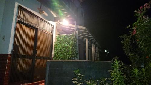 a house at night with a gate and plants at The Sloope Nagasaki in Nagasaki