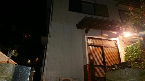 a house with a door with a gate at night at The Sloope Nagasaki in Nagasaki