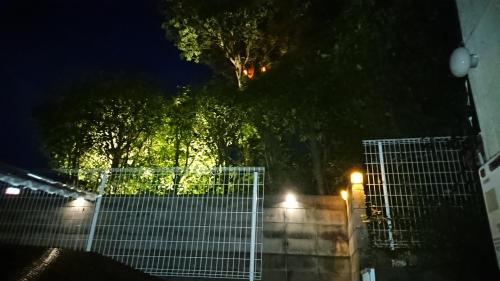 Ein Zaun vor einem Baum in der Nacht in der Unterkunft The Sloope Nagasaki in Nagasaki