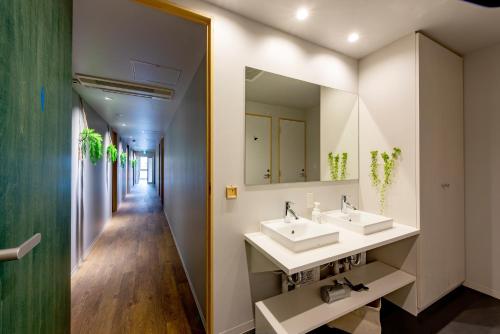 a bathroom with two sinks and a mirror at plat hostel keikyu minowa forest in Tokyo