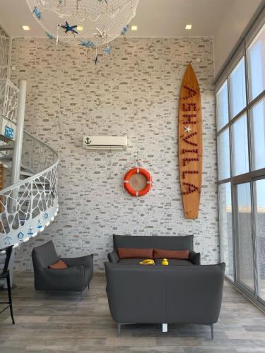 a living room with a couch and a surfboard on the wall at Ash Villa in Al Ashkharah