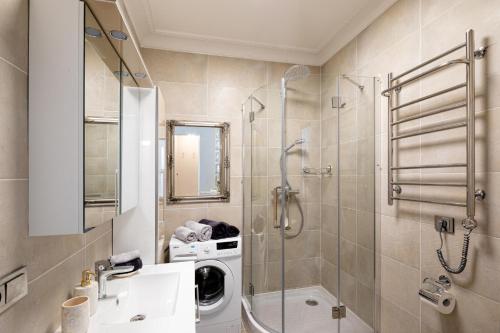 a bathroom with a shower and a sink and a washing machine at Art Design King Bed Studio Apartment In Old Town in Rīga