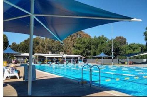 a large swimming pool with a large blue umbrella at Adelaide Style Accommodation - City to Beach - Free WIFI - Free 3 car parking - Great location in Adelaide