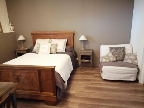 1 dormitorio con 2 camas y 2 mesas con lámparas en Chambre d'hôtes La Ruzardière, en Combourtillé
