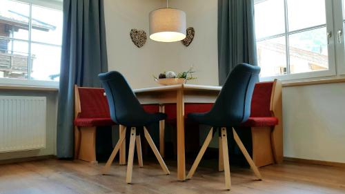 a bar with two chairs and a table in a room at Haus Veronika - Appartements by Miha in Westendorf