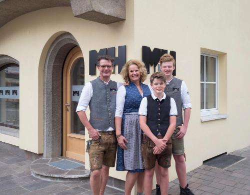 a woman and her family standing in front of a building at Haus Veronika - Appartements by Miha in Westendorf