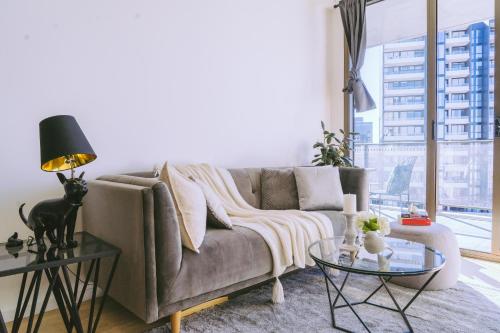a living room with a couch and a glass table at Capitol Executive Apartment on London Circuit in Canberra