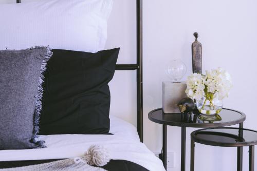 a bedroom with a bed and a table with flowers on it at Capitol Executive Apartment on London Circuit in Canberra
