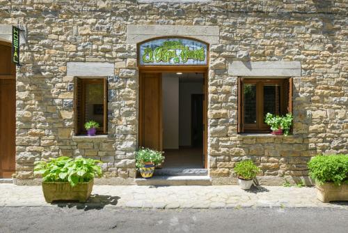 an entrance to a stone building with potted plants at Hostal Bosque de Gamueta in Ansó