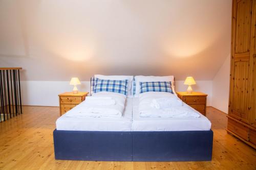 a large bed in a room with two night stands at Exklusives Landhaus in Šatov