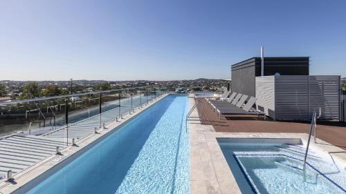 a large swimming pool on top of a building at Oaks Brisbane Woolloongabba Suites in Brisbane