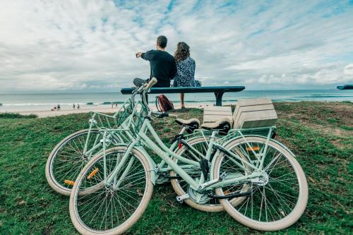 a man and a woman sitting at a picnic table on the beach at Wake Up! Byron Bay in Byron Bay