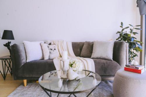 a living room with a couch and a glass table at Capitol Executive Apartment on London Circuit in Canberra