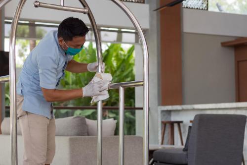 a man in a mask and gloves working on a metal rail at Best Western Kamala Jimbaran in Jimbaran