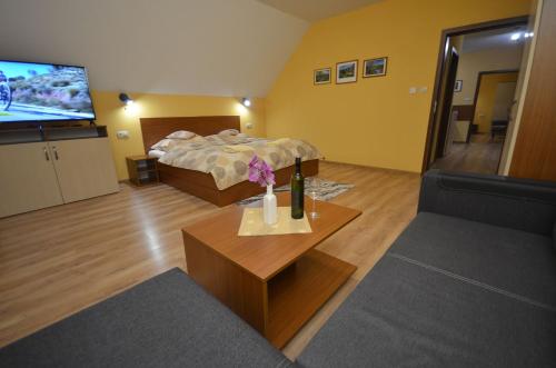 a living room with a bed and a tv at Apartmány Best I. Bešeňová in Bešeňová