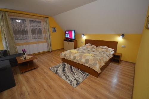 a bedroom with a bed and a flat screen tv at Apartmány Best I. Bešeňová in Bešeňová