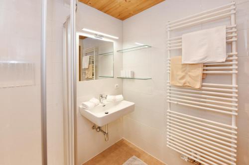 een witte badkamer met een wastafel en een spiegel bij Ferienwohnung Fiel in Sankt Gallenkirch