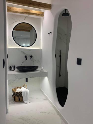 a bathroom with a mirror and a sink at Hotel Palatia in Naxos Chora