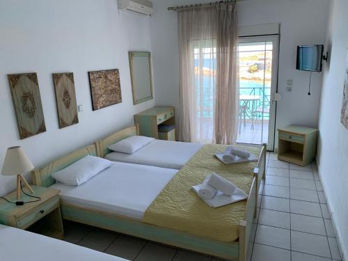 a hotel room with two beds and a balcony at Studios Apollonia in Skala Marion