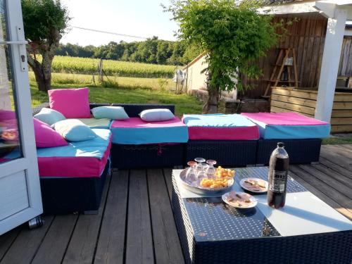 eine Terrasse mit Sofas und einem Tisch mit Essen darauf in der Unterkunft Yourte mongole véritable in Montcaret