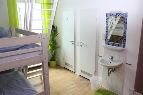 a bathroom with a bunk bed and a sink at Townside Hostel Bremen in Bremen