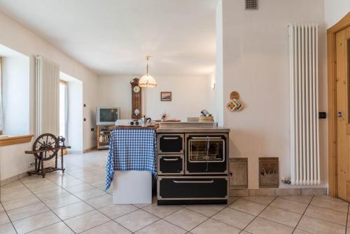 a kitchen with an oven and a tile floor at Baita Serpillo in Palù del Fersina