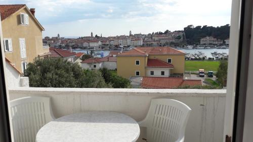 a balcony with a table and chairs and a view of a city at Piadora in Banjol