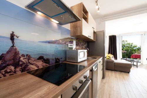 a kitchen with a painting of a man on a cliff at Apartment Majda Opatija in Opatija